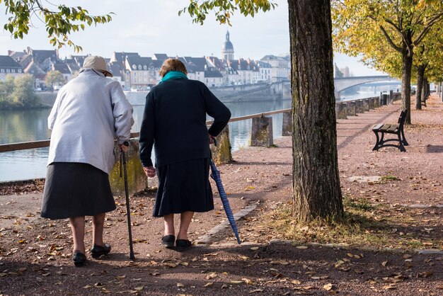Foto achtergrondbeeld van oudere vrouwen die op het veld bij het meer lopen