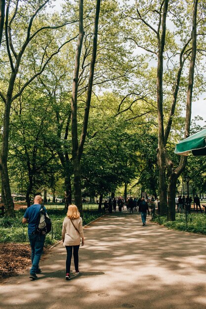 Foto achtergrondbeeld van vader en dochter die op de weg lopen te midden van bomen in het park