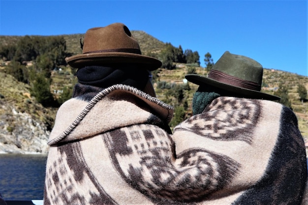Foto achtergrondbeeld van vrienden die een deken dragen tegen bergen
