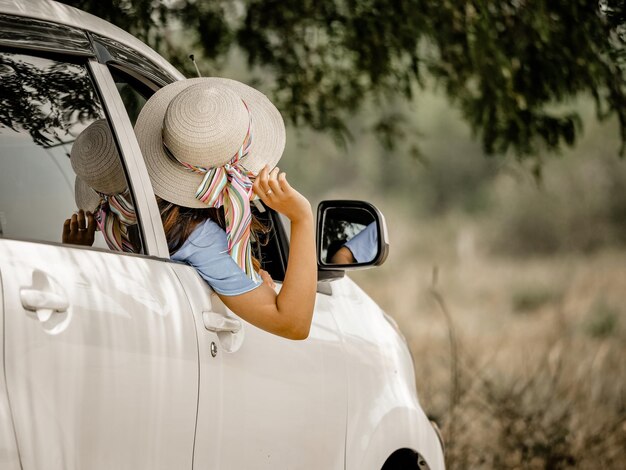 Foto achtergrondbeeld van vrouw met hoed terwijl ze in de auto zit