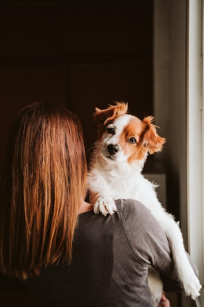 Foto achtergrondbeeld van vrouw met hond die thuis staat