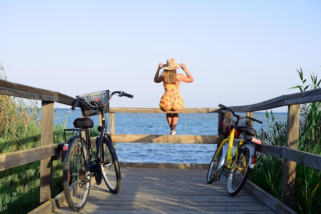 Foto achtergrondbeeld van vrouw op fiets bij zee tegen een heldere lucht