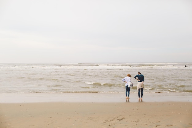 Achtergrondbeeld van vrouwen die aan de kust staan tegen de lucht