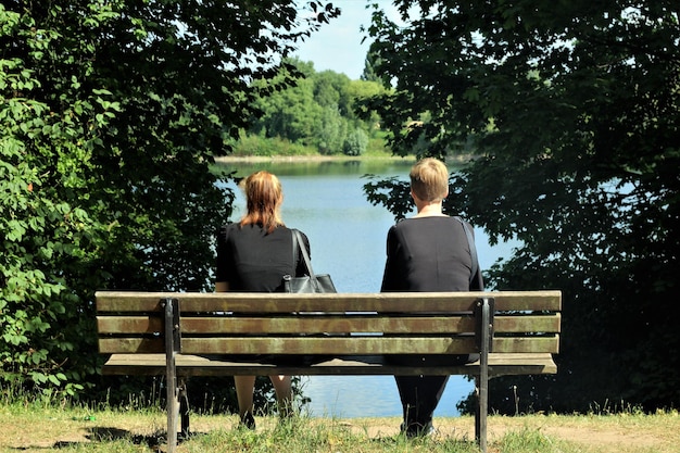 Achtergrondbeeld van vrouwen die op een bankje bij het meer zitten