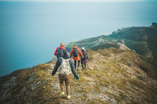 Foto achtergrondbeeld van wandelaars die op de berg tegen de zee lopen