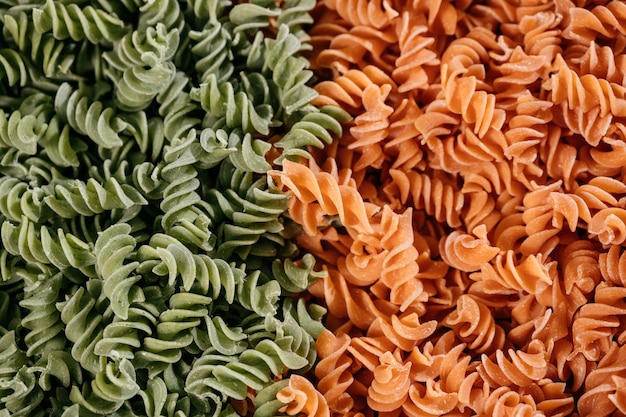 Achtergrondstructuur van driekleurige fusilli pasta voor traditionele Italiaanse en mediterrane keuken in een close-up full frame weergave. Hoge kwaliteit foto