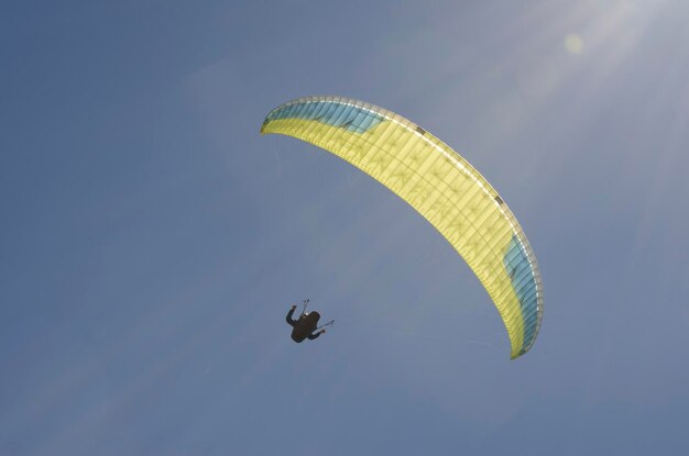 achtergrondverlichte paraglidingvlucht met zon en blauwe lucht