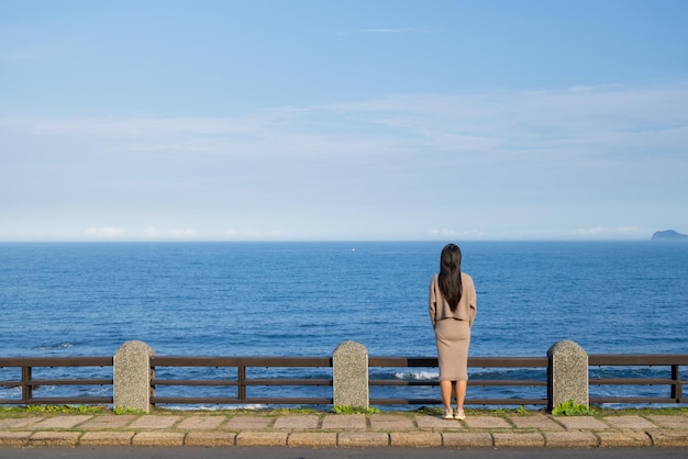 Achterkant van de vrouw kijkt naar de zee