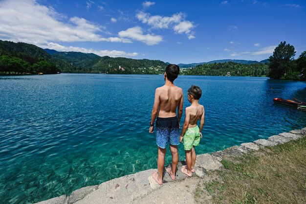 Achterkant van twee broers staan in de pier van het prachtige Bled-meer van Slovenië