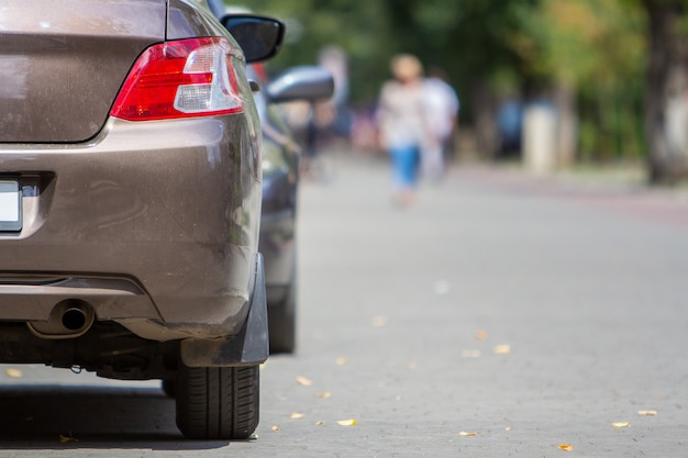 Achterlicht van een auto geparkeerd in de buurt van stoeprand aan de kant van de straat op een parkeerplaats.