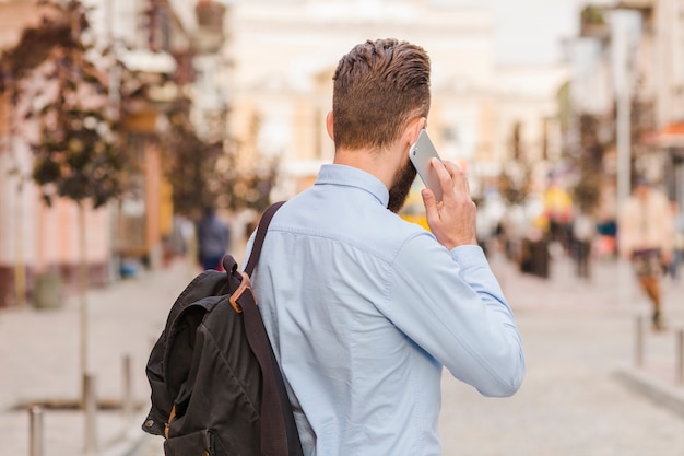 Achtermening van een mens die op cellphone spreekt