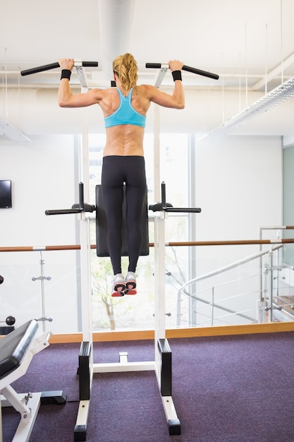 Foto achtermening van geschikte vrouw die trekkracht ups doen bij gymnastiek