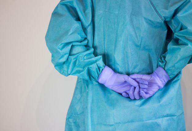 Foto achtermening van verpleger gekleed in coronavirus beschermingsmateriaal.