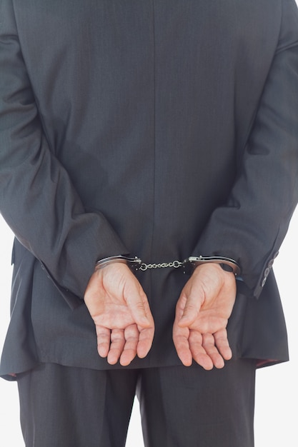 Achtermening van zakenman met handcuffs