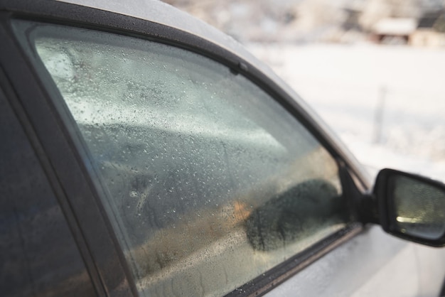 Achteruitkijkspiegels zijn bedekt met condens Regendruppels en water op de zijspiegel van de auto