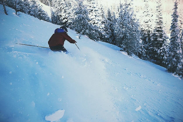 Achteruitzicht van een skiër op een met sneeuw bedekt landschap