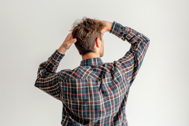 Foto achteruitzicht van een verwarde jonge toevallige man met zijn hand op de achterkant van zijn hoofd geïsoleerd op wit
