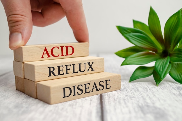 Acid reflux disease word with man's hand on white background