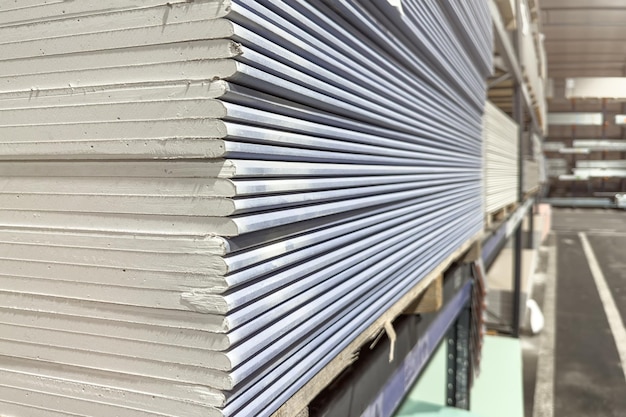 Photo acoustic drywall blue plasterboard panel designed for soundproofing walls and ceilings a stack of drywall in a hardware store in a warehouse copy space