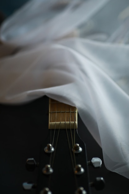 An acoustic guitar for an artist playing a stringed musical\
instrument on stage. black guitar with a capo. musical\
background.