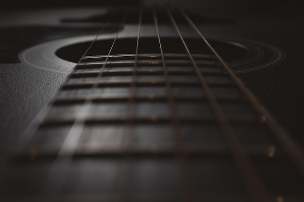 Photo acoustic guitar closeup selective focus visible neck strings soundboard resonator