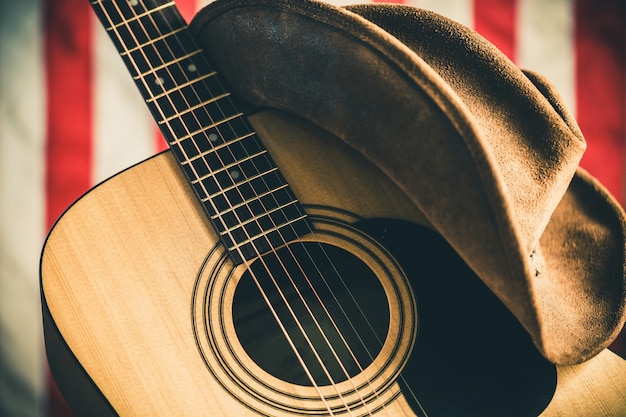 Acoustic Guitar and Cowboy Hat with American Flag on Background