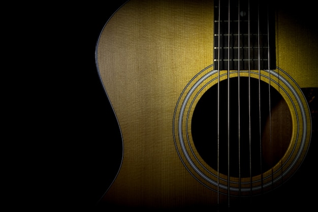 Foto chitarra acustica isolata su fondo nero, immagine scura