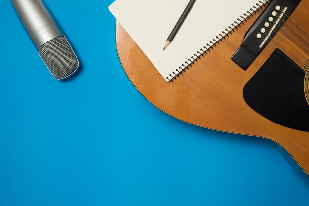 Acoustic guitar and microphone On the color background