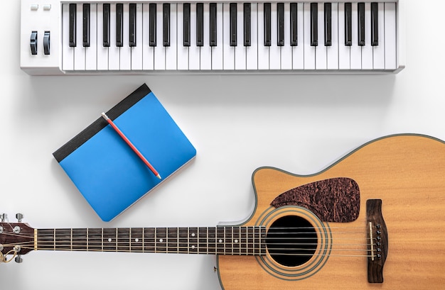 Acoustic guitar and musical keys on a white background flat lay