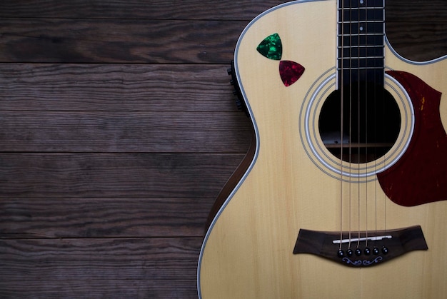 Acoustic guitar on an old wooden table See only the acoustic guitar body Closeup Copyspace