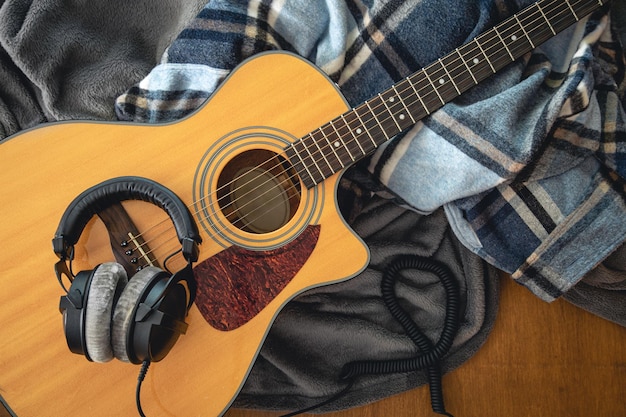 Acoustic guitar plaids and and headphones top view