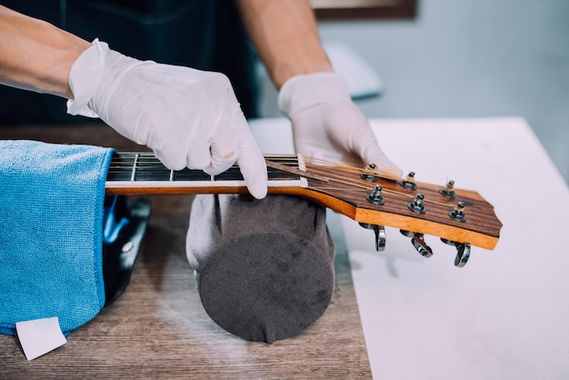 Acoustic guitar repairman fixing the guitar neck closeup