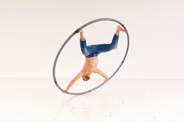 Acrobat doing coin trick with cyr wheel