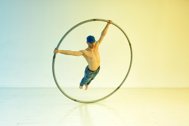 Acrobat training on a cyr wheel performing a superman trick