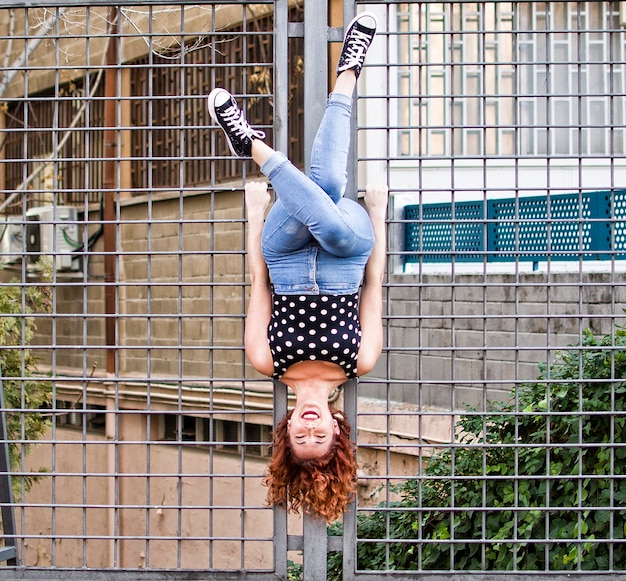 Acrobat woman doing a flip on the wall