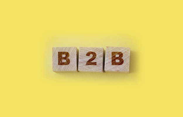 Фото Акроним b2b business to business wooden cubes on yellowbusiness concept