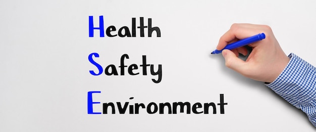 Photo acronym hse or health safety environment the person writes the text with a marker