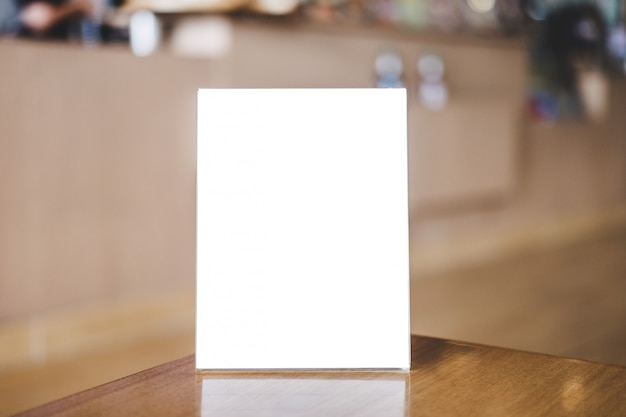 Photo acrylic blank frame template, blank menu frame on table in coffee shop or restaurant