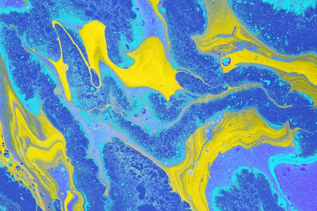 Acrylic Fluid Art. Free flow of yellow and blue colors creates marble effect. Abstract background or texture.