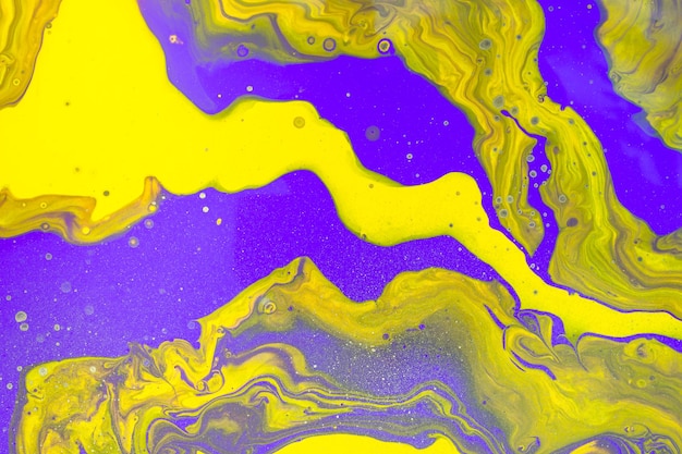 Acrylic Fluid Art. Glowing purple and yellow waves with gold inclusion. Abstract marble background or texture.