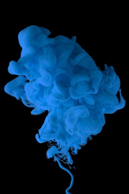 Acrylic ink in water form an abstract smoke pattern isolated on black background