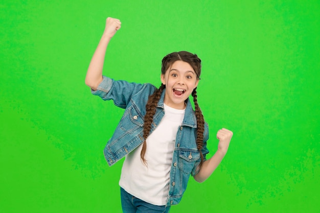 Act like winner today. Happy winner celebrate win green background. Little child make winning gesture. Celebrating victory or success. Beauty look. Casual fashion. Trendy style. Your are lucky winner.