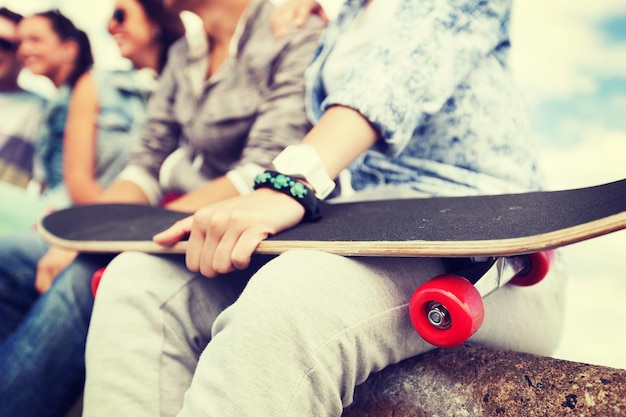 Foto concetto di attività e vacanze estive - primo piano della mano femminile che tiene lo skateboard