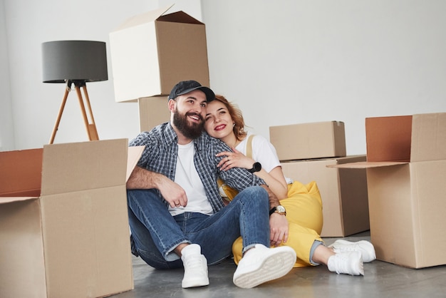 Actief gesprek. Gelukkig paar samen in hun nieuwe huis. Conceptie van verhuizen