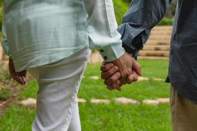 Foto actief ouder echtpaar staat hand in hand in de tuin