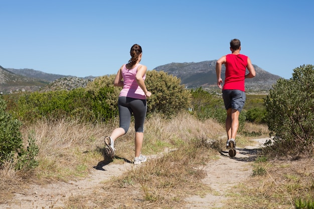 Actief paar joggen op het terrein van het land