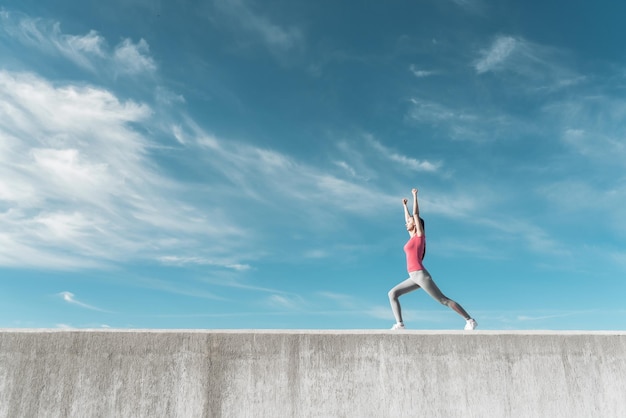 Actief slank meisje dat spieren kneedt en buiten yoga doet