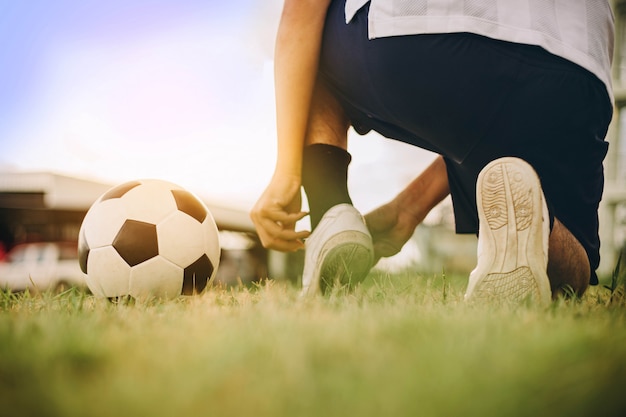 Foto actiesport in openlucht van de voetballer die van de voetbalbal voor oefening speelt