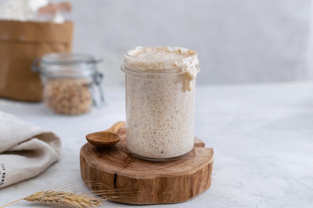 Actieve bubbelende zuurdesembroodstarter, gezond fermentatieproces op lichte tafel