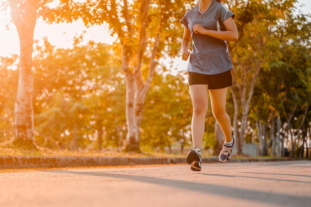 Actieve gezonde loper joggen buiten. Vrouw joggen in het park in zonsopganglicht